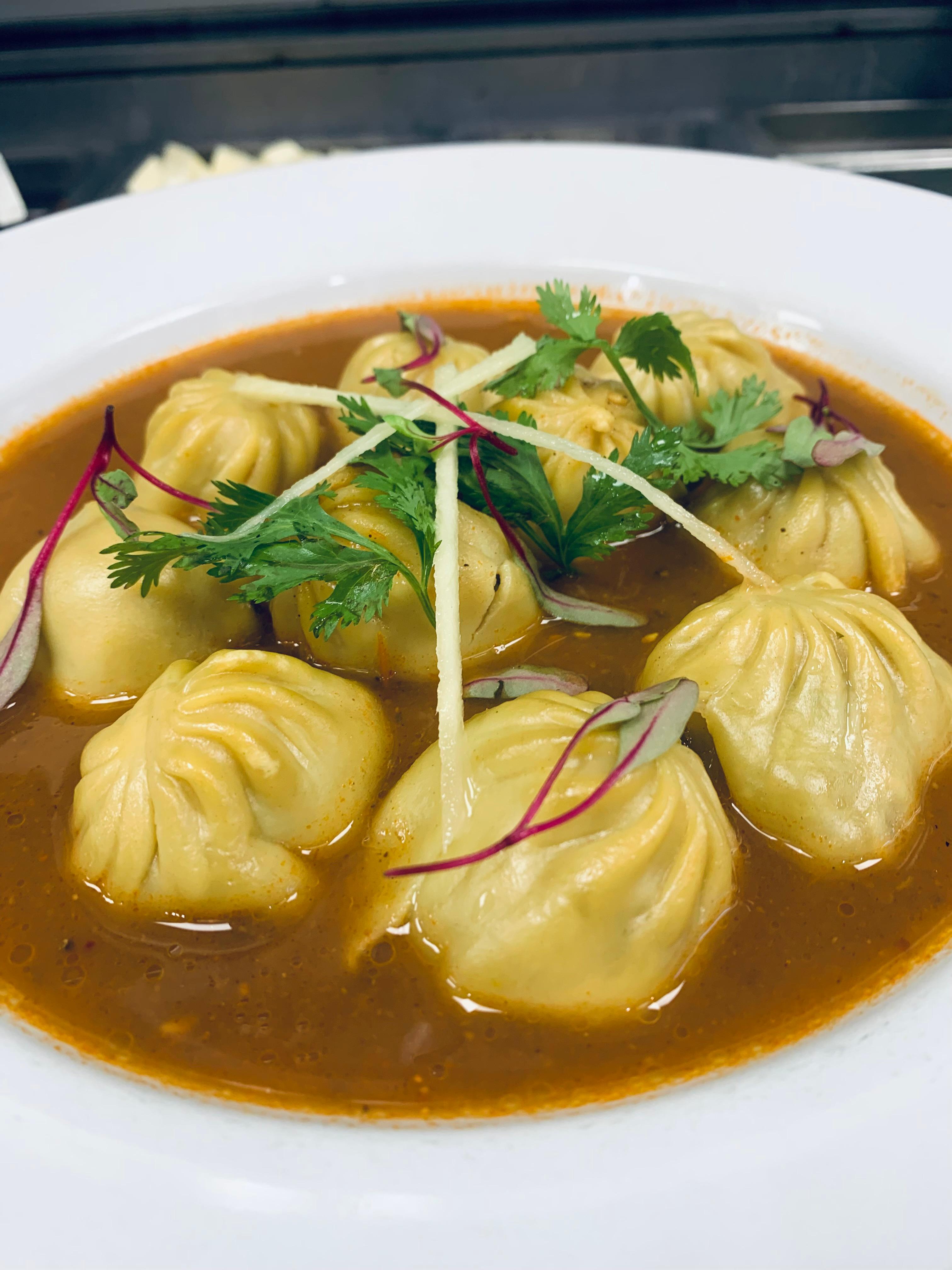 Jhol momo served in aromatic spiced broth